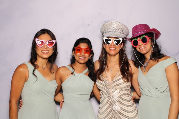 Bride and bridesmaids smiling with glasses on