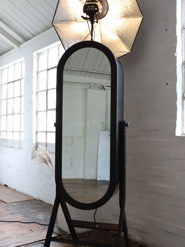Black retro style Magic Mirror Photo Booth in white industrial room