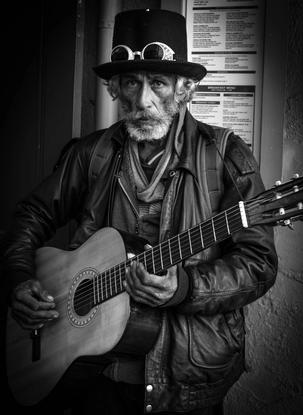 Black and white portrait of an elderly street musician.