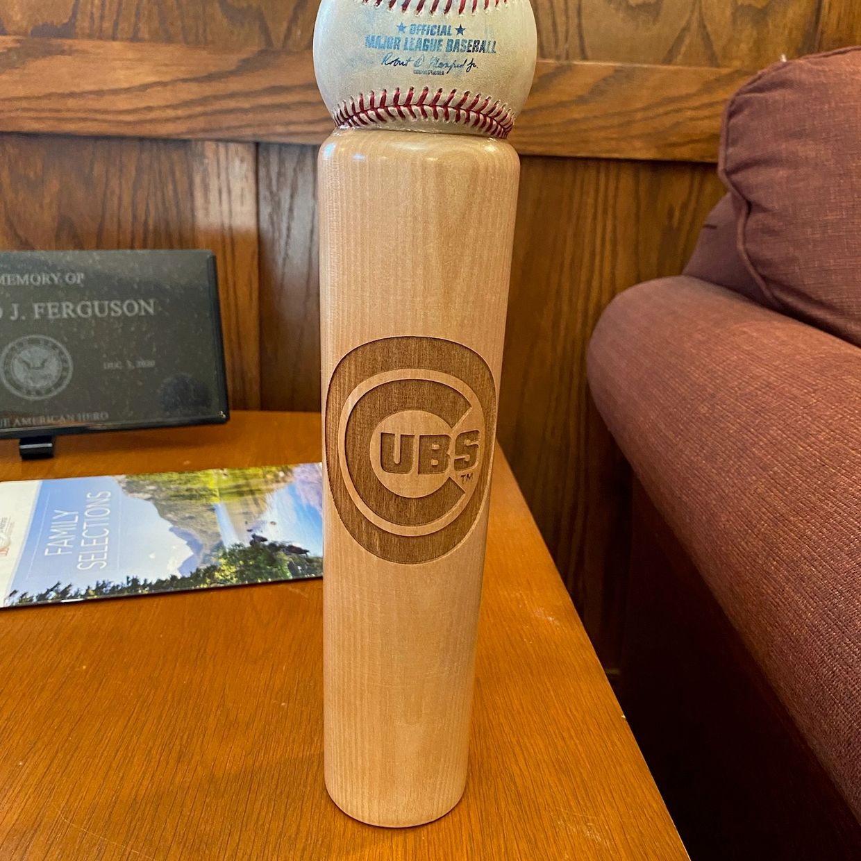 Baseball bat with Chicago Cubs logo and an official baseball on top.
