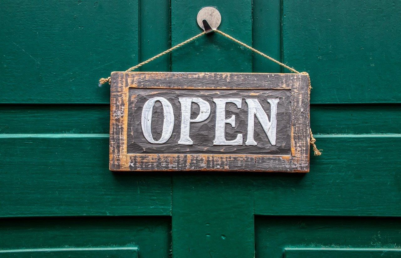 A sign saying OPEN on a green door.  Virtual Head Office.