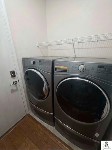 Modern front-load washer and dryer set in a clean residential laundry room next to a door.