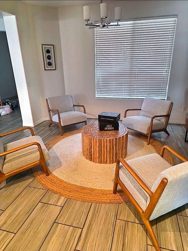 Modern living room seating area with four armchairs and a central coffee table.