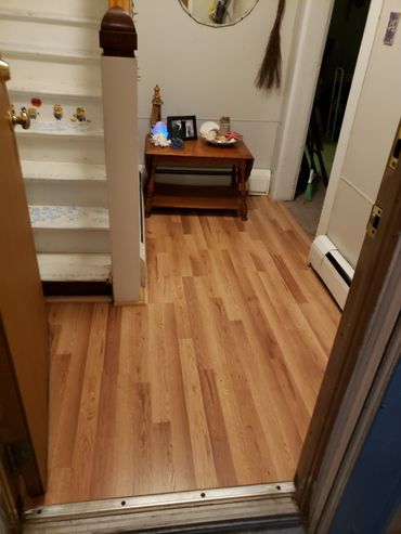 Hallway with wooden floor, decorated table, and stairs with Minion stickers.