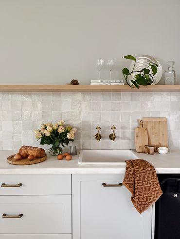 Coastal bar. Light grey shaker cabinetry, white concrete benchtop, handmade tiles & floating shelf