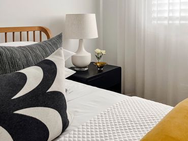 Modern bedroom with transitional rug, velvet doona, linen sheer curtains and Marimekko curtains