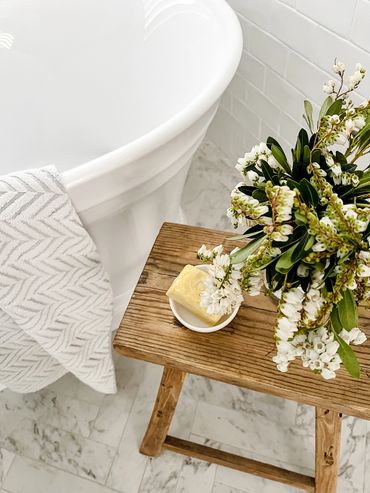 Light-filled Hamptons bathroom with freestanding bath and herringbone marble floors