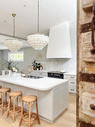 Coastal Kitchen with timber door, light grey shaker cabinetry, concrete benchtop and zellige tiles.