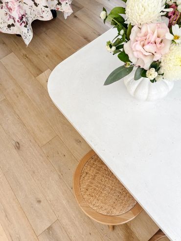 Curved oncrete kitchen benchtop detail, oak floors and rattan stool.
