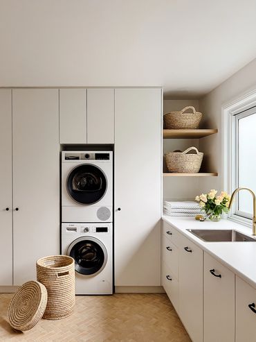 Light-filled, modern laundry with white cabinetry, herringbone floor tiles & floating timber shelf