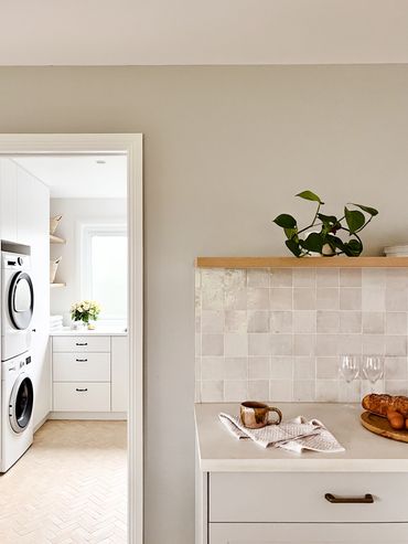 Coastal bar. Light grey shaker cabinetry, white concrete benchtop, handmade tiles & floating shelf