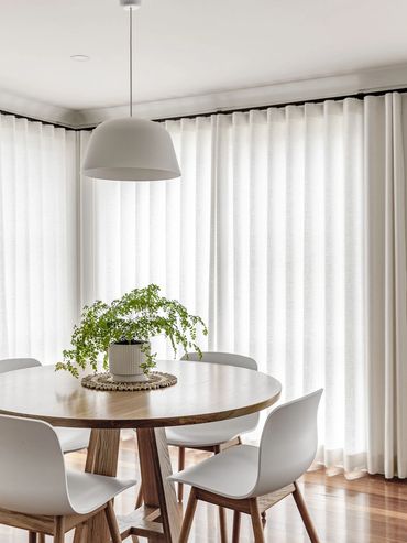 Mid-Century Modern Dining room with white pendant light, oak table and hardwood floor.