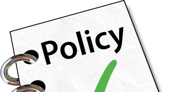 Close-up of a policy document with a green check mark.