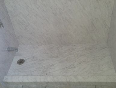 Marble look anti-slip shower floors installed during shower conversions from an old bathtub.