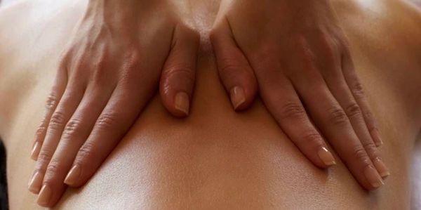 Hands giving a relaxing back massage.