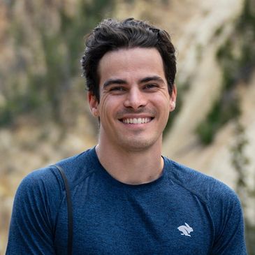 Smiling man in blue shirt outdoors.