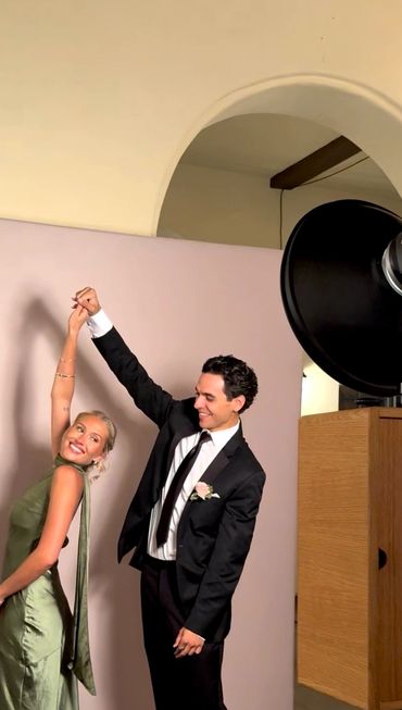 A couple dancing joyfully, dressed elegantly for a formal event.