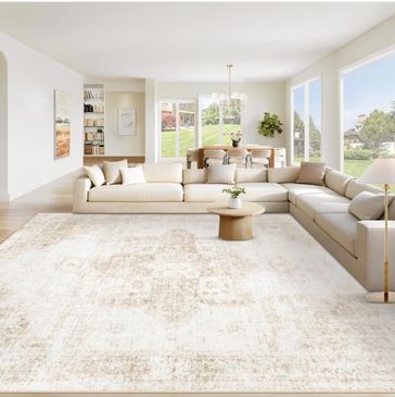 Spacious living room with beige sectional sofa and large windows.