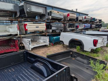 Pickup truck beds at a salvage yard.