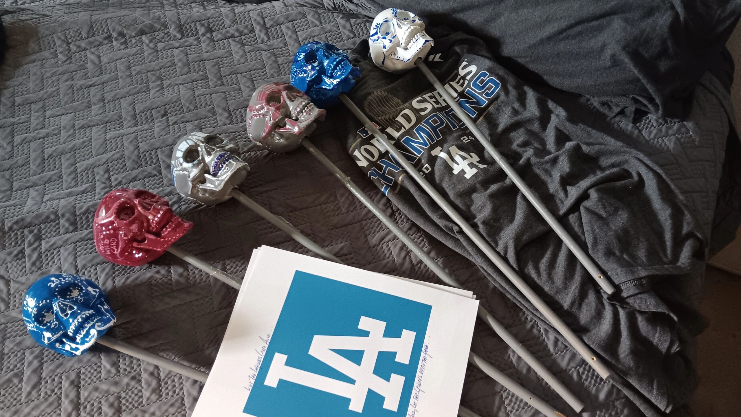 Painted skull heads on sticks with a Dodgers World Series shirt.