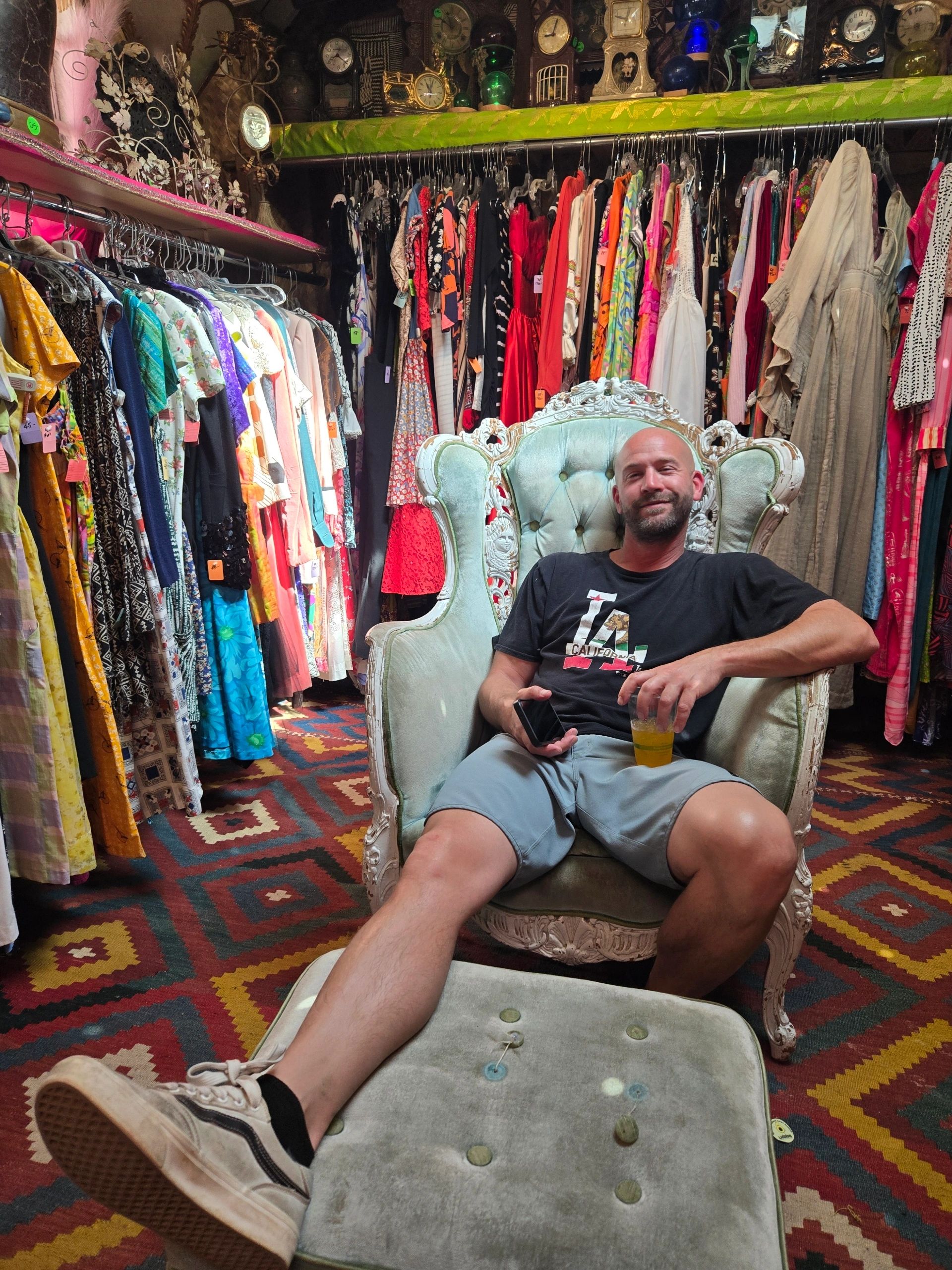 Man relaxing in a vintage clothing store chair.