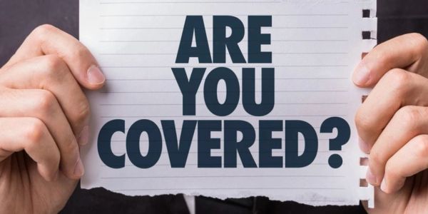 Person holding a sign asking, "Are you covered?"