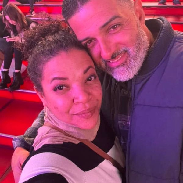 Couple taking a close-up selfie with red stairs in the background.