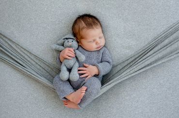 A sleeping newborn in a hammock/sling.