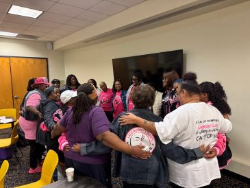 Group of women in a circle showing unity indoors.