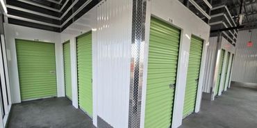 Interior view of a storage facility with green roll-up doors.