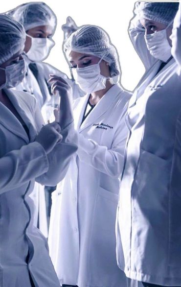 Medical team in protective gear discussing patient data.