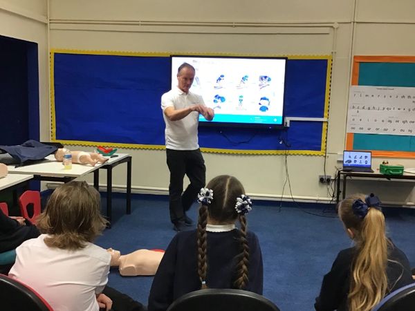 A classroom of students learning the basics of first aid