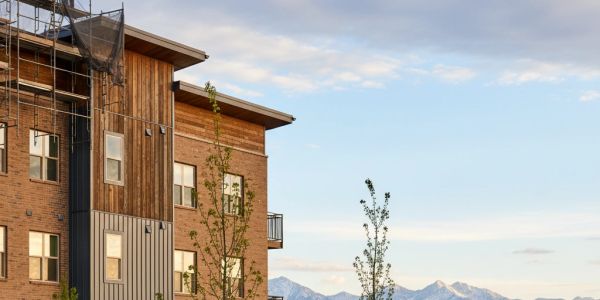 Modern apartment building with mountain backdrop.
