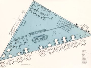 Triangle building plan drawing of bar/ restaurant on light powder blue background.