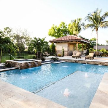 Luxury backyard pool and spa with covered spillways into pool, large cabo bench, deck jets on either side of spa, and raised bond beam wall with scupper water features.