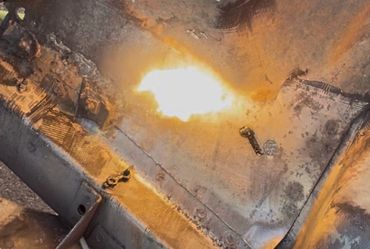 Flame welding or cutting metal with sparks flying.