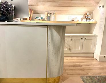 concrete reception desk with computer on top amnd shelves in the background