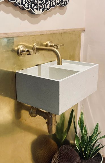 Our Deep Deane sink in white mounted against a brass splash back with brass taps.
