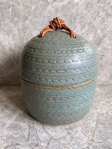 carved stoneware jar with leather knot
