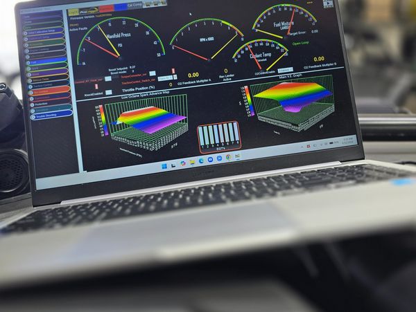 Laptop displaying vehicle engine diagnostics and performance data.