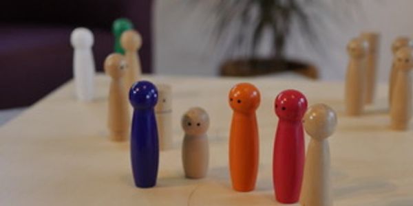 A group of wooden figures, representing a group of persons.