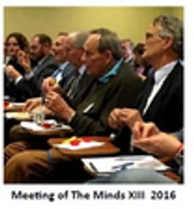 Dr. Martin (dark coat) enjoys speaker at the Symposium he designed.