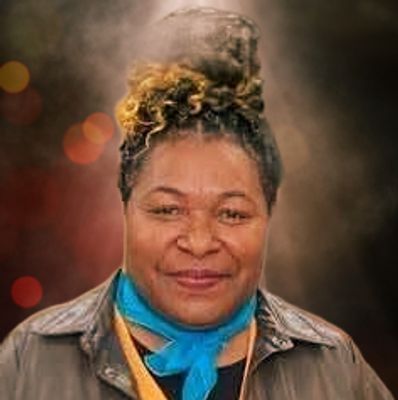 Woman with a blue scarf and curly hair smiling.