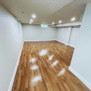 Empty room with polished wooden floor and white walls.