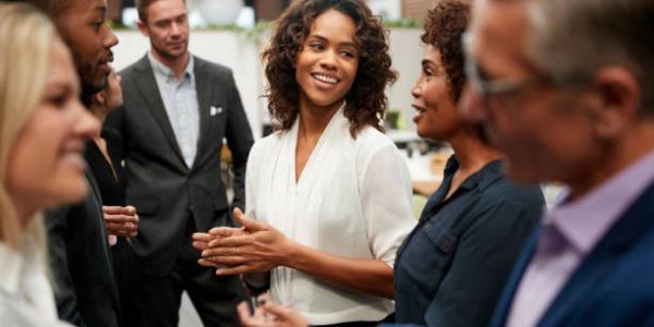 A diverse group of professionals networking and smiling at an event.
