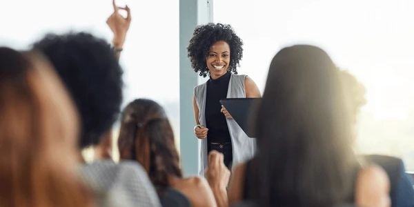 A woman confidently presenting to an engaged audience.
