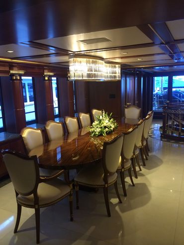 yacht dining room. Crystal overhead chandelier and sleek recess lighting.