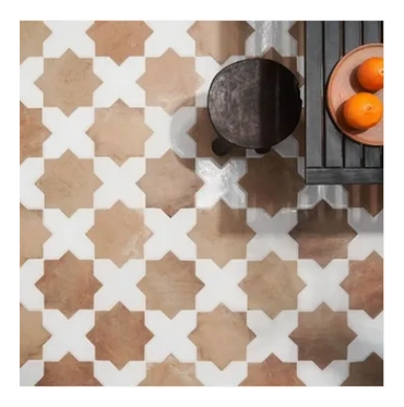 Geometric patterned floor tiles in beige and white tones with a wooden table and stool.