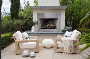 Cozy outdoor seating with modern fireplace and natural decor.