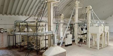 Industrial machinery setup inside a warehouse with pipes and conveyors.